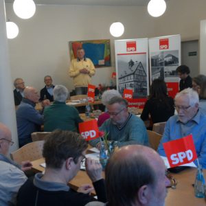 Schnappschuss der Versammlung im AWO Café während der Begrüßung der Mitglieder durch Rainer Fich